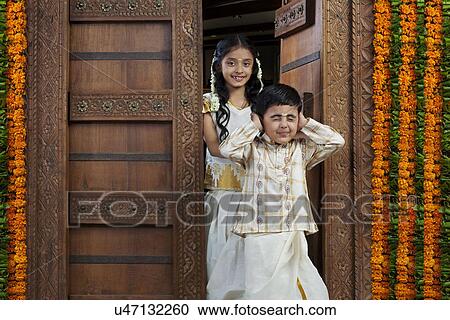Stock Image - South Indian girl standing with her brother . Fotosearch