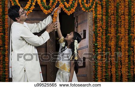South Indian man helping his daughter decorate View Large Photo Image Stock Photography - South Indian man helping his daughter decorate . Fotosearch