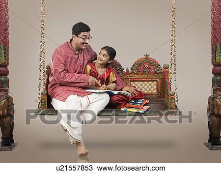 Stock Image - South Indian man teaching his daughter . Fotosearch