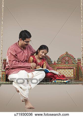 Stock Photograph - South Indian man teaching his daughter . Fotosearch