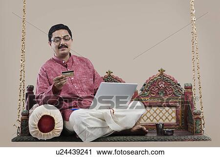 South Indian man with a credit card and laptop View Large Photo Image Stock Image - South Indian man with a credit card and laptop . Fotosearch