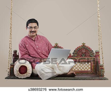 South Indian man with a laptop View Large Photo Image Stock Photograph - South Indian man with a laptop . Fotosearch