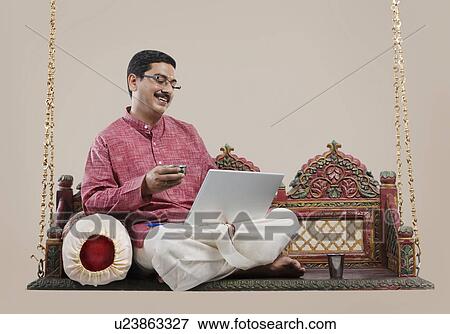 South Indian man working on a laptop View Large Photo Image Stock Photo - South Indian man working on a laptop . Fotosearch