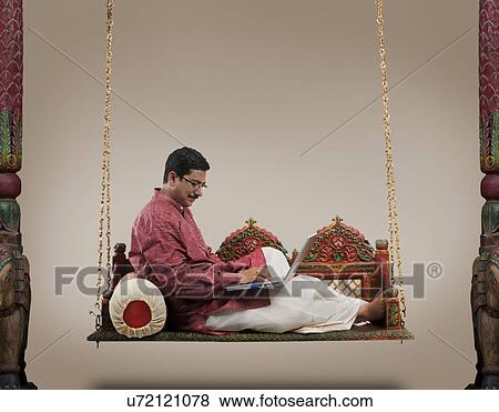 South Indian man working on a laptop View Large Photo Image Stock Photo - South Indian man working on a laptop . Fotosearch