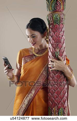 South Indian woman looking at her mobile phone View Large Photo Image Stock Photo - South Indian woman looking at her mobile phone . Fotosearch