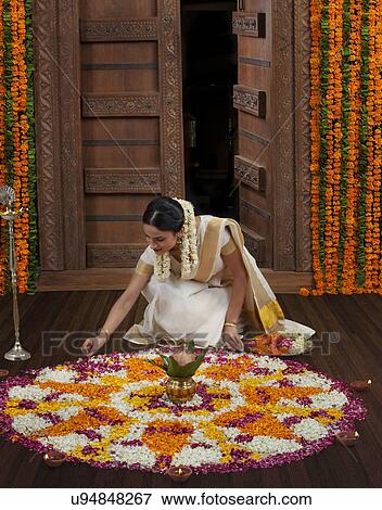 Stock Photo - South Indian woman making a flower rangoli . Fotosearch