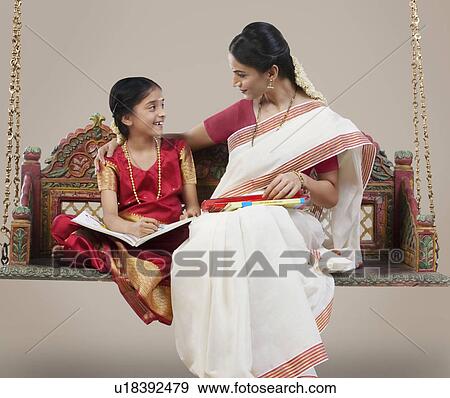 South Indian woman sitting with her daughter View Large Photo Image Stock Photo - South Indian woman sitting with her daughter . Fotosearch