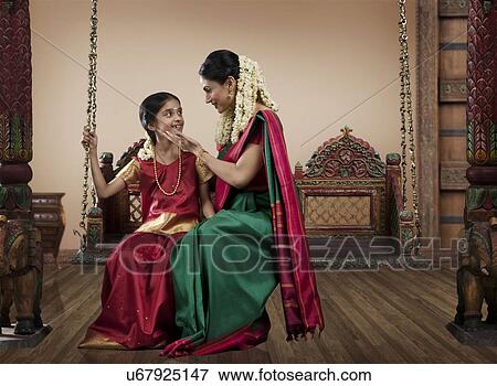 South Indian woman sitting with her daughter on a jhula View Large Photo Image Stock Photo - South Indian woman sitting with her daughter on a jhula . Fotosearch