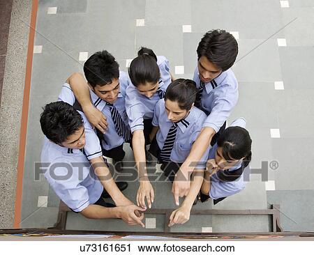 Stock Image - Students pointing at a notice board . Fotosearch
