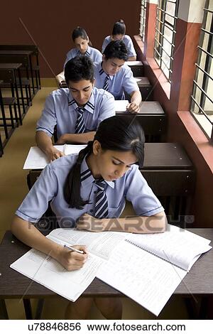 Students writing in notebooks in a classroom View Large Photo Image Stock Photograph - Students writing in notebooks in a classroom . Fotosearch