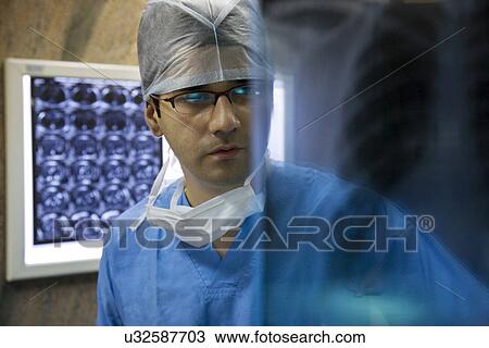 Surgeon looking at an X-ray chart View Large Photo Image Stock Image - Surgeon looking at an X-ray chart . Fotosearch