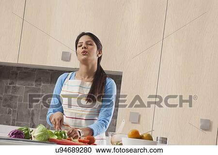 Tired woman cutting vegetable in kitchen View Large Photo Image Stock Image - Tired woman cutting vegetable in kitchen. Fotosearch