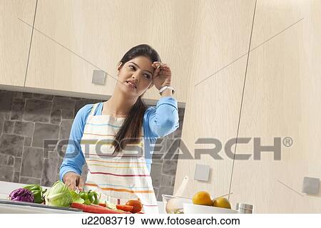 Tired woman preparing food in kitchen View Large Photo Image Stock Photo - Tired woman preparing food in kitchen. Fotosearch