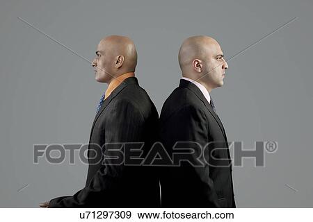 Stock Photo - Two bald businessmen standing back to back . Fotosearch