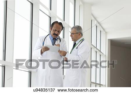 Two doctors with a digital tablet View Large Photo Image Stock Photo - Two doctors with a digital tablet. Fotosearch