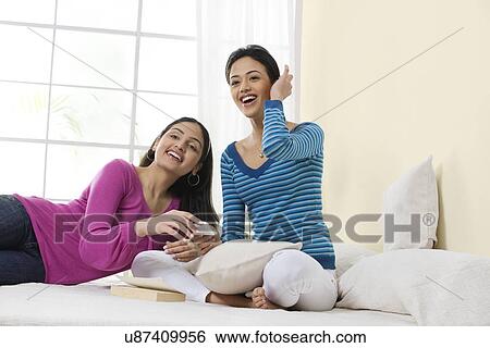Two girls with a mobile phone View Large Photo Image Stock Photograph - Two girls with a mobile phone . Fotosearch