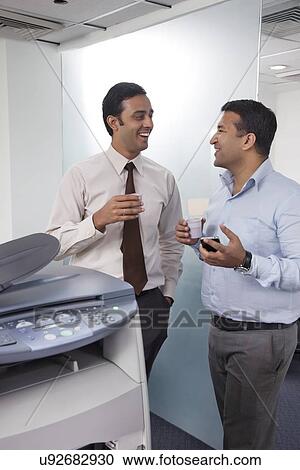 Stock Image - Two male executives chatting. Fotosearch