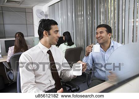 Two male executives having tea in office View Large Photo Image Stock Image - Two male executives having tea in office. Fotosearch