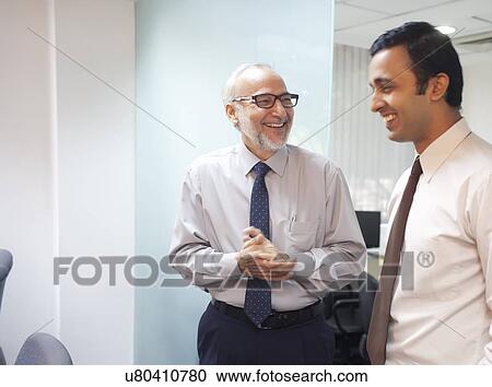 Two male executives smiling View Large Photo Image Stock Image - Two male executives smiling. Fotosearch