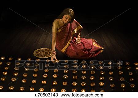 Woman arranging diyas View Large Photo Image Stock Image - Woman arranging diyas . Fotosearch