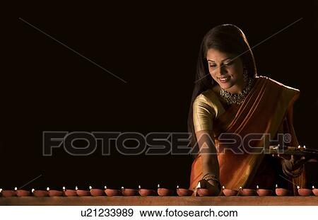 Stock Photo - Woman arranging diyas . Fotosearch