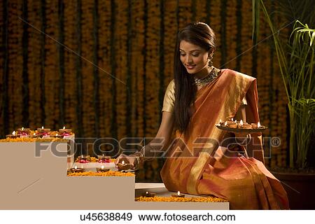 Stock Photo - Woman arranging diyas . Fotosearch