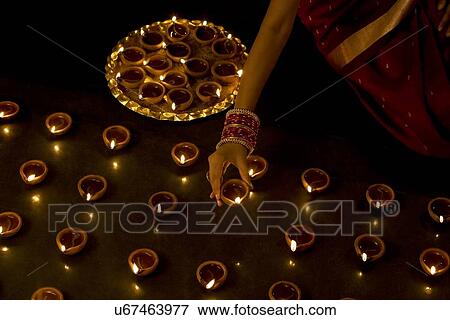 Stock Photo - Woman arranging diyas . Fotosearch