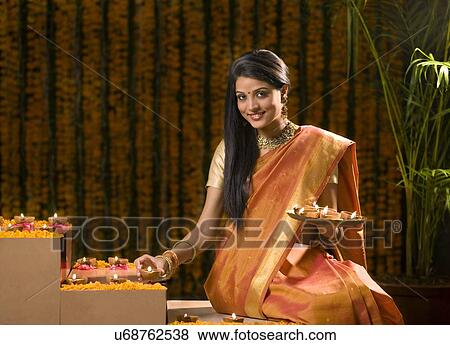 Woman arranging diyas View Large Photo Image Stock Photo - Woman arranging diyas . Fotosearch