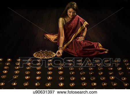 Woman arranging diyas View Large Photo Image Stock Photo - Woman arranging diyas . Fotosearch