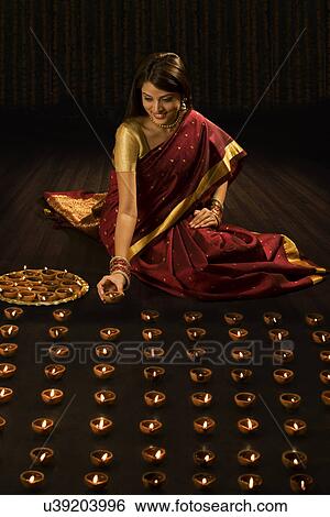 Woman arranging diyas View Large Photo Image Stock Photograph - Woman arranging diyas . Fotosearch