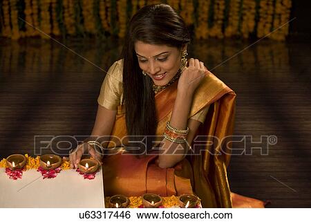 Woman arranging diyas View Large Photo Image Stock Photograph - Woman arranging diyas . Fotosearch