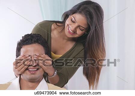 Woman covering mans eyes with her hands View Large Photo Image Picture - Woman covering mans eyes with her hands. Fotosearch
