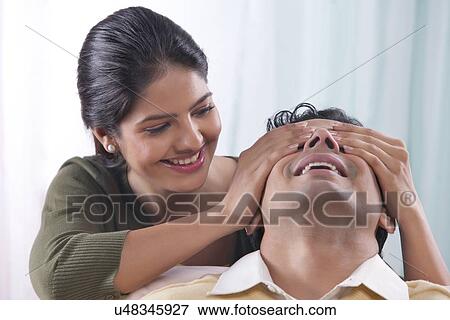 Woman covering mans eyes with her hands View Large Photo Image Stock Photo - Woman covering mans eyes with her hands. Fotosearch