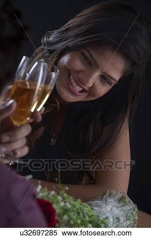 Stock Photography - Woman enjoying a glass of wine on Valentines Day. Fotosearch