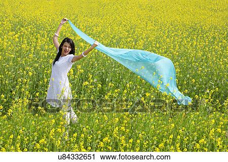 Stock Image - Woman enjoying herself in a field . Fotosearch