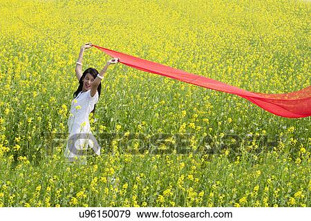 Woman enjoying herself in a field View Large Photo Image Stock Photo - Woman enjoying herself in a field . Fotosearch