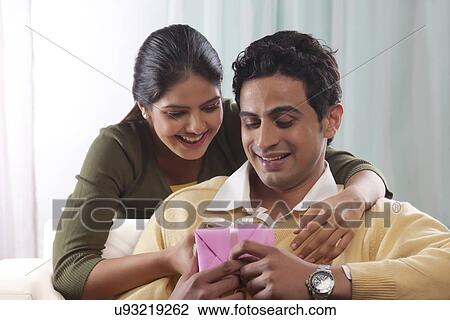 Stock Image - Woman giving a man a gift on Valentines Day. Fotosearch