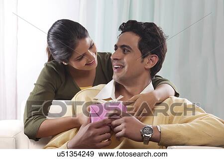 Stock Photo - Woman giving a man a gift on Valentines Day. Fotosearch