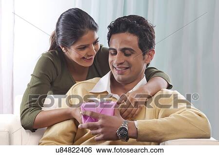Stock Photograph - Woman giving a man a gift on Valentines Day. Fotosearch