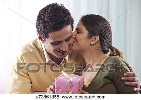 Stock Photo - Woman giving a man a kiss on Valentines Day. Fotosearch