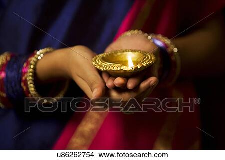 Woman holding a diya View Large Photo Image Picture - Woman holding a diya . Fotosearch