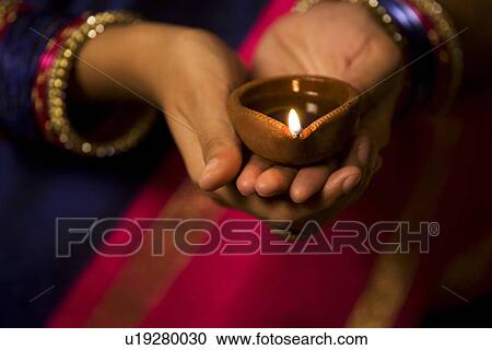 Woman holding a diya View Large Photo Image Stock Image - Woman holding a diya . Fotosearch