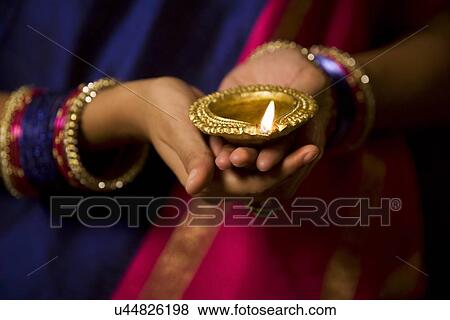 Woman holding a diya View Large Photo Image Stock Photo - Woman holding a diya . Fotosearch