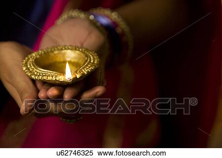Stock Photography - Woman holding a diya . Fotosearch