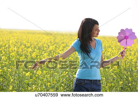 Woman holding a pinwheel in a field View Large Photo Image Stock Photo - Woman holding a pinwheel in a field . Fotosearch