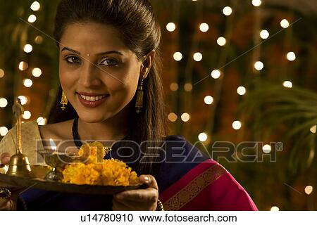 Woman holding a tray with a diya View Large Photo Image Stock Image - Woman holding a tray with a diya . Fotosearch