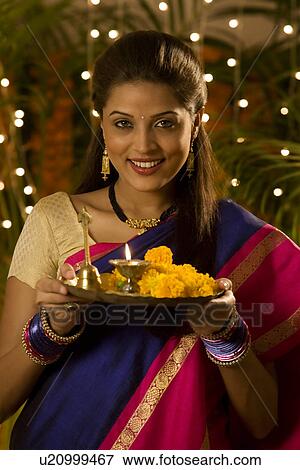 Woman holding a tray with a diya View Large Photo Image Stock Photo - Woman holding a tray with a diya . Fotosearch