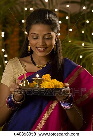 Woman holding a tray with a diya View Large Photo Image Stock Photo - Woman holding a tray with a diya . Fotosearch