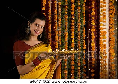 Woman holding a tray with diyas View Large Photo Image Stock Image - Woman holding a tray with diyas . Fotosearch