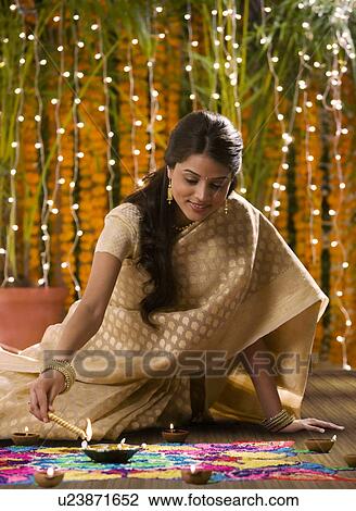 Woman lighting a diya View Large Photo Image Stock Image - Woman lighting a diya . Fotosearch